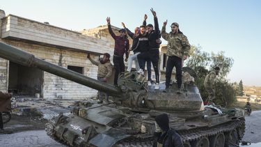 Partidarios de la oposición siria celebran arriba de un tanque de guerra del ejército sirio en el poblado de Maarat al-Numan, al suroeste de Alepo, Siria, el sábado 30 de noviembre de 2024. (AP Foto/Omar Albam)