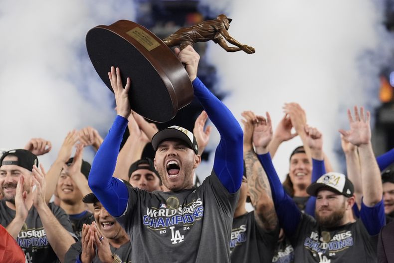Freddie Freeman, de los Dodgers de Los Ángeles, festeja tras obtener el trofeo al Jugador Más Valioso de la Serie Mundial, luego del triunfo sobre los Yankees de Nueva York en el quinto juego, el jueves 31 de octubre de 2024 (AP Foto/Ashley Landis)