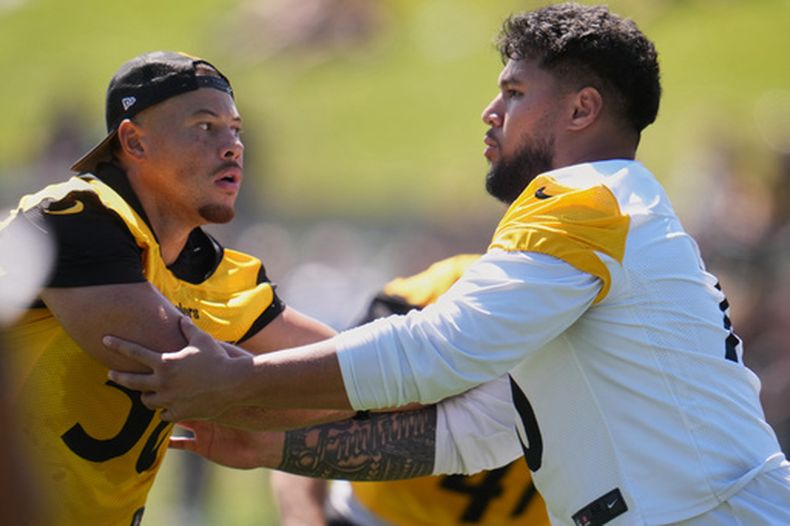 El apoyador de los Steelers de Pittsburgh, Alex Highsmith (56, a la izquierda), es bloqueado por el tacle ofensivo Troy Fautanu durante el campamento de entrenamiento de fútbol americano del equipo en Latrobe, Pensilvania, el viernes 31 de julio de 2026. (Foto AP/Gene J. Puskar)