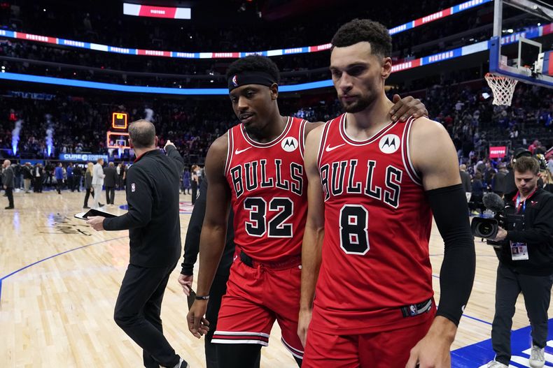 Terry Taylor y Zach LaVine, de los Bulls de Chicago, abandonan la cancha luego del encuentro ante los Pistons de Detroit, el sábado 28 de octubre de 2023 (AP Foto/Carlos Osorio)