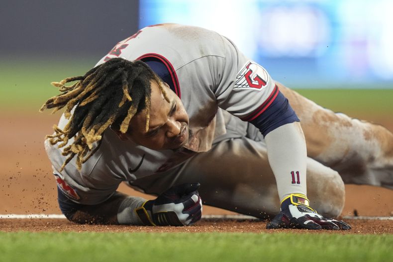José Ramírez, de los Guardianes de Cleveland, cae después de llegar a primera base con un sencillo en contra de lo Azulejos de Toronto en la tercera entrada del juego de béisbol de Grandes Ligas, el viernes 2 de mayo de 2025, en Toronto. (Chris Young/The Canadian Press vía AP)