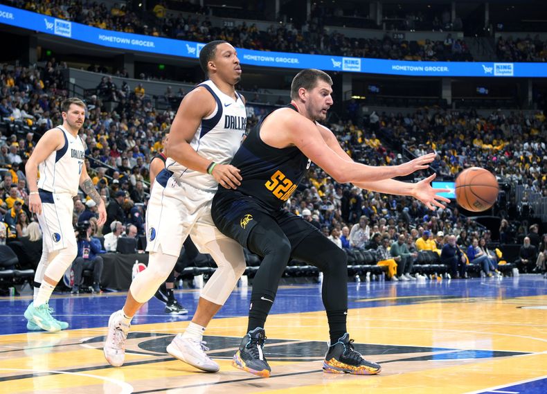 Nikola Jokic, de los Nuggets de Denver, recibe un pase frente a Grant Williams, de los Mavericks de Dallas, en el partido del viernes 3 de noviembre de 2023 (AP Foto/David Zalubowski)
