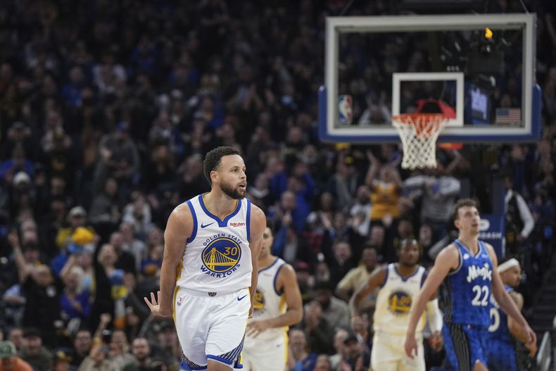Stephen Curry, de los Warriors de Golden State, festeja luego de atinar un triple en el encuentro ante el Magic de Orlando, el martes 2 de enero de 2024 (AP Foto/Loren Elliott)