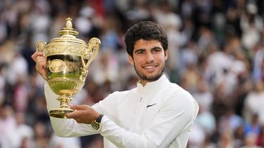 Carlos Alcaraz alza el trofeo de campeón de Wimbledon tras derrotar a Novak Djokovic en la final, el domingo 16 de julio de 2023, en Londres. (AP Foto/Kirsty Wigglesworth)