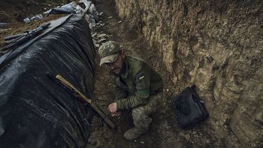 Un soldado ucraniano se sienta en una trinchera en el frente cerca de Bájmut, en la región de Donetsk, Ucrania, el lunes 22 de mayo de 2023. (AP Foto/Libkos)