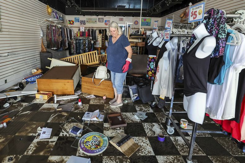 Jill Rice observa los daños causados en su tienda por la inundación provocada por el paso del huracán Helene, el 27 de septiembre de 2024, en Gulfport, Florida. (AP Foto/Mike Carlson)
