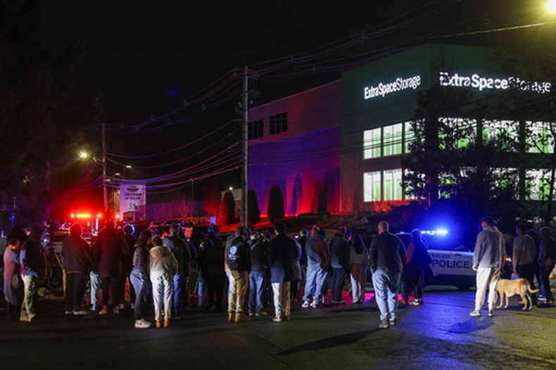 Personas se reúnen afuera de un almacén donde se encontró muerto a un sospechoso del tiroteo en la Universidad de Brown, el jueves 18 de diciembre de 2025, en Salem, Nueva Hampshire. (Foto AP/Reba Saldanha)