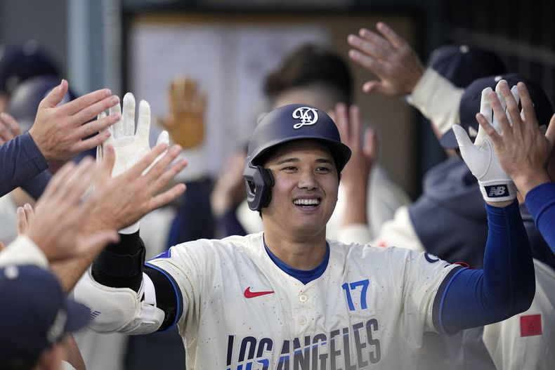 El japonés Shohei Ohtani, de los Dodgers de Los Ángeles, festeja en la cueva luego de conseguir un jonrón de dos carreras ante los Angelinos de la misma ciudad, el sábado 22 de junio de 2024 (AP Foto/Mark J. Terrill)