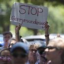 Una mujer sostiene una pancarta durante una protesta contra la audiencias de redistribución de mapas electorales en el Capitolio de Texas, el jueves 24 de julio de 2025, en Austin, Texas. (AP Foto/Eric Gay)