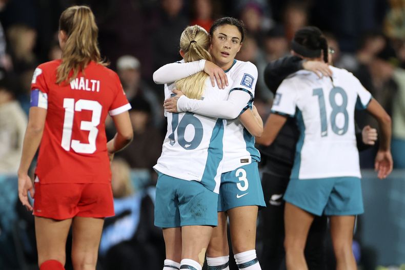 Las neozelandesas Claudia Bunge (derecha) y Jacqui Hand se abrazan tras el empate 0-0 contra Suiza en el Mundial femenino, el domingo 30 de julio de 2023, en Dunedin, Nueva Zelanda. (AP Foto/Matthew Gelhard)
