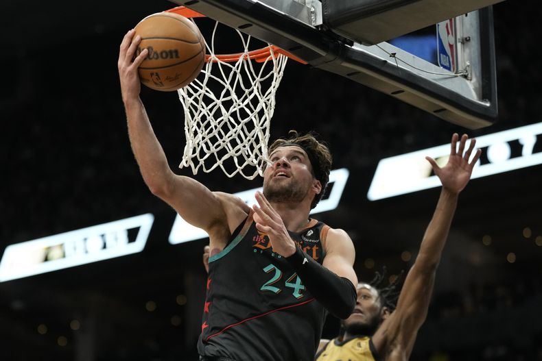 El alero de los Wizards de Washington, Corey Kispert (24), salta a la canasta mientras el escolta de los Raptors de Toronto, Immanuel Quickley, defiende durante la segunda mitad de un partido de baloncesto de la NBA en Toronto, el domingo 7 de abril de 2024. (Frank Gunn/The Canadian Press vía AP)