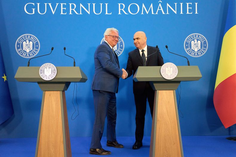 El primer ministro rumano, Ilie Bolojan, derecha, estrecha la mano del director ejecutivo de la alemana Rheinmetall AG, Armin Papperger, tras una rueda de prensa conjunta celebrada en Bucarest, Rumania, el lunes 3 de noviembre de 2025, después de la firma de un acuerdo de colaboración para la construcción de una fábrica de pólvora para municiones. (Foto AP/Vadim Ghirda)