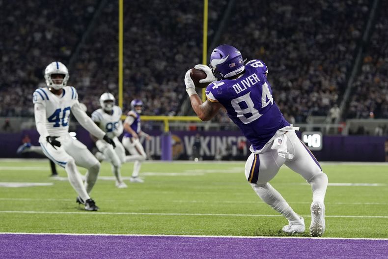 Josh Oliver (84), tight end de los Vikings de Minnesota, atrapa un pase de anotación de 14 yardas durante la segunda mitad del partido de la NFL en contra de los Colts de Indianápolis, el domingo 3 de noviembre de 2024, en Minneapolis. (AP Foto/Abbie Parr)