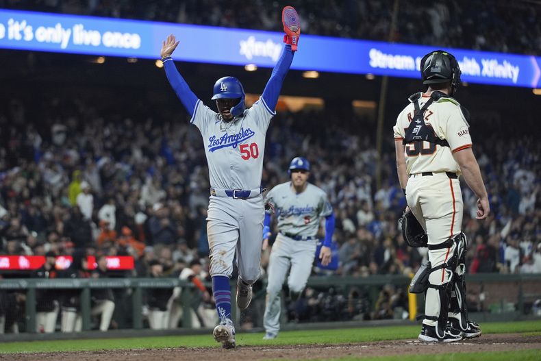 Mookie Betts (50), de los Dodgers de Los Ángels, celebra mientras anota en contra de los Gigantes de San Francisco con doble de Will Smith durante la 10ma entrada del juego de béisbol, el lunes 13 de mayo de 2024, en San Francisco. (AP Foto/Godofredo A. Vásquez)