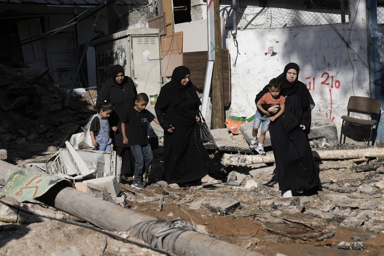 Mujeres y niños revisan la destrucción causada por una incursión del ejército israelí en el campo de refugiados palestinos de Nur Shams, el 20 de octubre de 2023, en Cisjordania. (AP Foto/Majdi Mohammed)