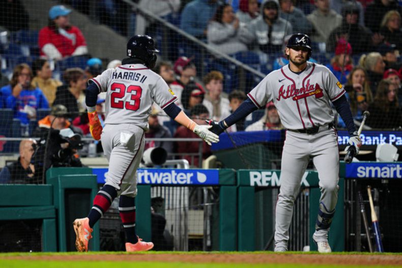 Michael Harris II (23), de los Bravos de Atlanta, celebra con Austin Riley, a la derecha, después de anotar durante la quinta entrada de un juego de béisbol contra los Filis de Filadelfia, el domingo 19 de abril de 2026, en Filadelfia. (AP Foto/Derik Hamilton)