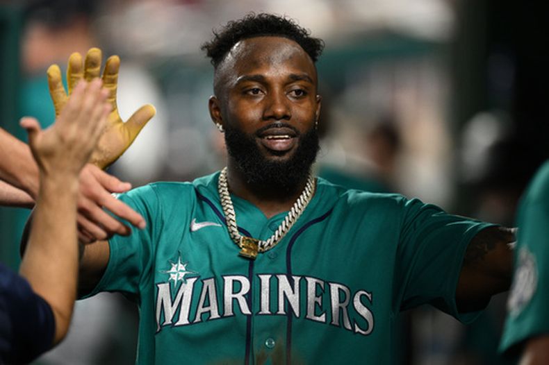 Randy Arozarena, de los Marineros de Seattle, celebra en el dugout tras anotar gracias a un triple de Dominic Canzone durante la segunda entrada de un partido de béisbol, el viernes 12 de junio de 2026, en Washington. (Foto AP/Nick Wass)
