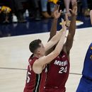 El serbio Nikola Jokic, de los Nuggets de Denver, dispara frente a Duncan Robinson, del Heat de Miami, en el primer partido de las Finales de la NBA, el jueves 1 de junio de 2023 (AP Foto/David Zalubowski)