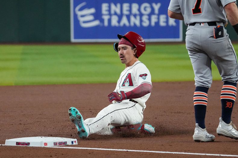 Corbin Carroll (7), de los Diamondbacks de Arizona, se desliza en la tercera base tras conectar un triple contra los Tigres de Detroit durante la primera entrada de un juego de béisbol del día inaugural, el lunes 30 de marzo de 2026, en Phoenix. (Foto AP/Darryl Webb)