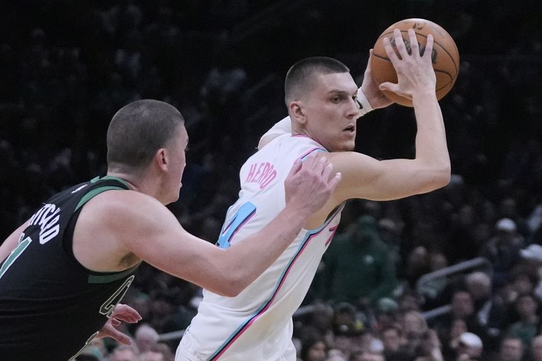 Tyler Herro, base del Heat de Miami, busca enviar un pase frente a Payton Pritchard, de los Celtics de Boston, el miércoles 2 de abril de 2025 (AP Foto/Charles Krupa)