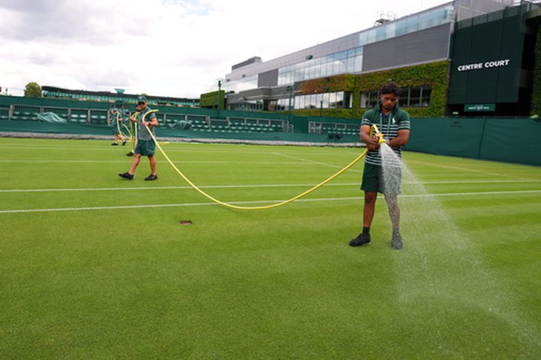 Personal riega las canchas antes del inicio de la jornada Wimbledon en el All England Club el domingo 28 de junio del 2026. (AP Foto/Kirsty Wigglesworth)