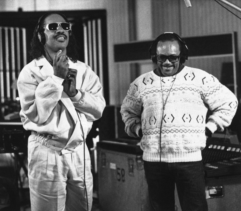 ARCHIVO - El astro Stevie Wonder, izquierda, y Quincy Jones participan en una sesión de grabación de costa a costa, vinculada a un estudio en Nueva York, para grabar una canción antidrogas, el miércoles 5 de marzo de 1987 en Los Ángeles. (Foto AP/Sunny Bak, archivo)