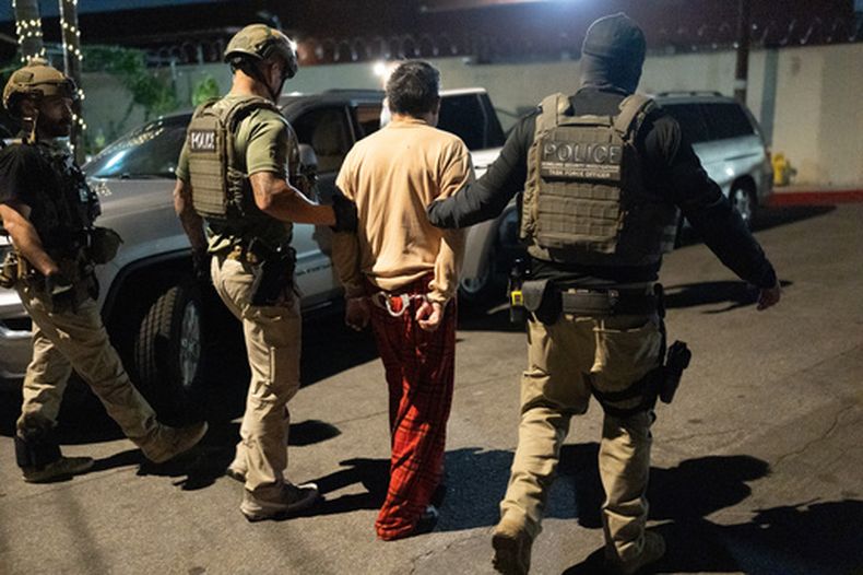 Policías escoltan a una persona acusada de votar ilegalmente en Commerce, California, el 19 de octubre del 2026. (AP foto/Jae C. Hong)