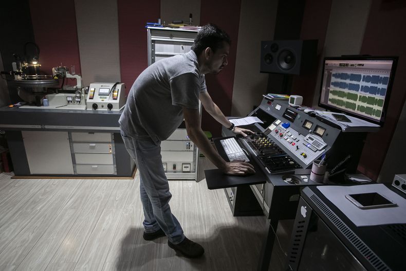 El operador de sonido William Carvalho prepara los audios para comenzar a editar un álbum, parte de la primera etapa de producción de vinilo en la fábrica Polysom, en Belford Roxo, Brasil, el martes 16 de abril de 2024. En 2008, el productor João Augusto y sus socios compraron y resucitaron Polysom, entonces una antigua planta de prensado de vinilo. Quince años después, Polysom ha impreso 1,3 millones de discos y sus competidores abrieron otras dos fábricas en Brasil. (Foto AP/Bruna Prado)