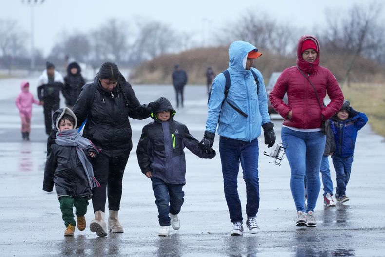ARCHIVO - Inmigrantes corren bajo la lluvia hacia las tiendas de campaña en el recinto Floyd Bennett Field, el martes 9 de enero de 2024, en Nueva York. (Foto AP /Mary Altaffer, Archivo)