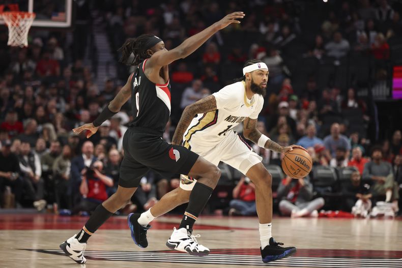 Brandon Ingram, alero de los Pelicans de Nueva Orleáns, conduce el balón frente a Jerami Grant, de los Trail Blazers de Portland, en el partido del viernes 25 de octubre de 2024 (AP Foto/Amanda Loman)