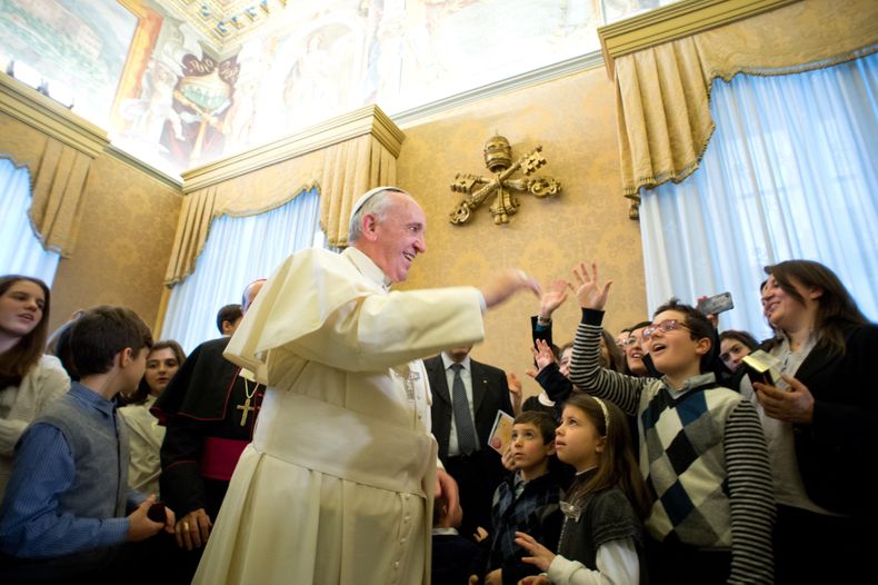 En imagen proporcionada por el diario del Vaticano, LOsservatore Romano, el papa Francisco es recibido por ni&ntilde;os durante una audiencia el viernes 21 de diciembre de 2013. El papa advirti&oacute; el s&aacute;bado a los administradores del Vaticano