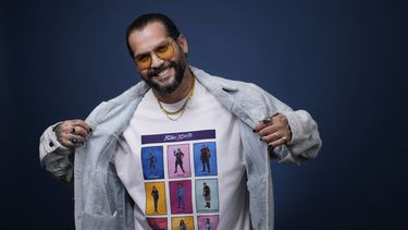Ángel Manuel Soto, director de Blue Beetle, muestra una camiseta con el elenco de la película al posar para un retrato el 4 de agosto de 2023, en el Hotel London en West Hollywood, California. El elenco no pudo promover la película por la huelga de actores de Hollywood. (Foto AP/Chris Pizzello)