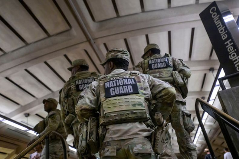 Miembros de la Guardia Nacional de Arkansas continúan su patrullaje tras bajar a una anciana en silla de ruedas debido a que el ascensor de la estación Columbia Heights del metro estaba fuera de servicio, el lunes 10 de agosto de 2026, en Washington. (AP Foto/Rod Lamkey, Jr.)