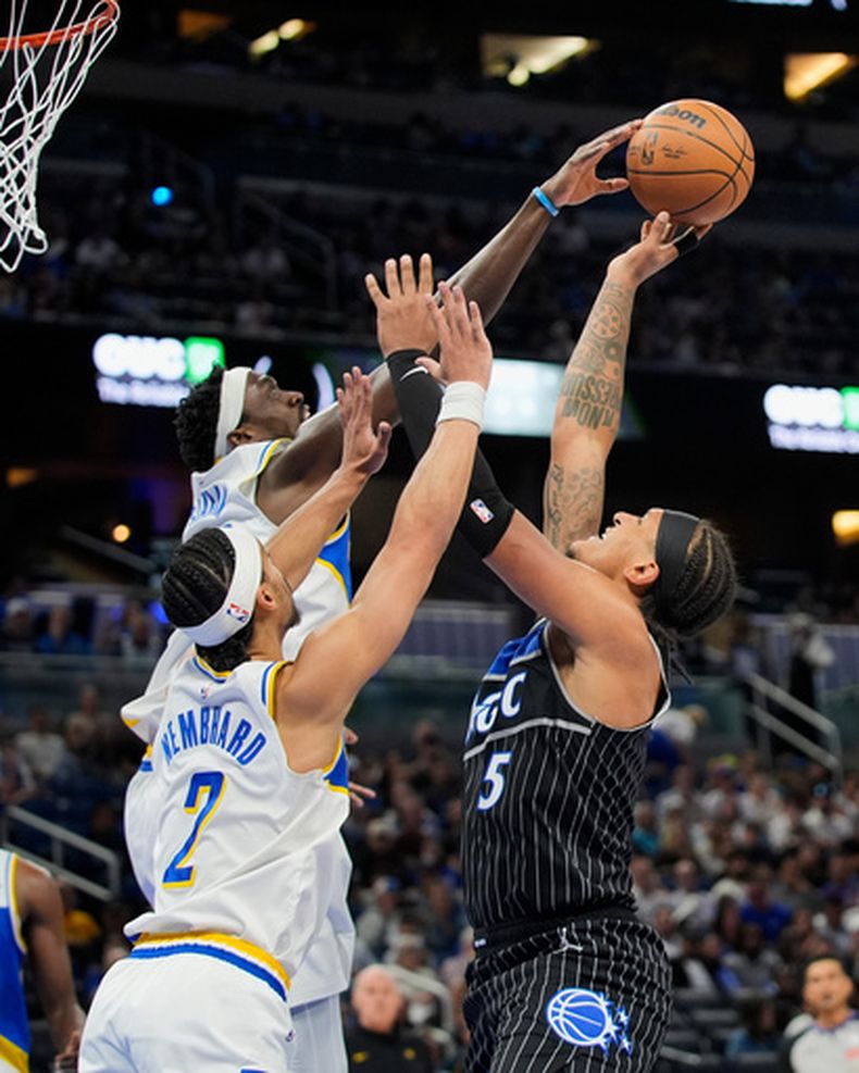 Paolo Banchero (5), del Magic de Orlando, batalla para intentar un disparo frente a Andrew Nembhard (2) y Pascal Siakam, de los Pacers de Indiana, durante la primera mitad del juego de baloncesto de la NBA del lunes 23 de marzo de 2026, en Orlando, Florida. (AP Foto/John Raoux)