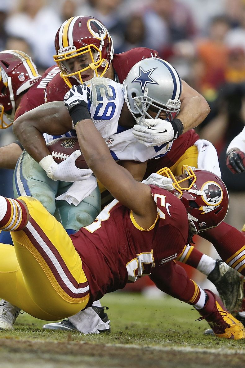 El running back DeMarco Murray es tacleado por el linebacker Ryan Kerrigan de los Redskins de Washington en el juego del domingo 22 de diciembre de 2013. (Foto de AP/Evan Vucci)