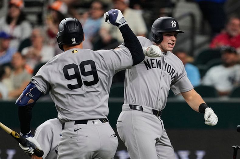 Aaron Judge (99) y Ben Rice, derecha, de los Yankees de Nueva York, celebran el cuadrangular de dos carreras de Rice en la tercera entrada del juego de béisbol de Grandes Ligas contra los Rangers de Texas, el lunes 27 de abril 2026, en Arlington, Texas. (AP Foto/Tony Gutierrez)
