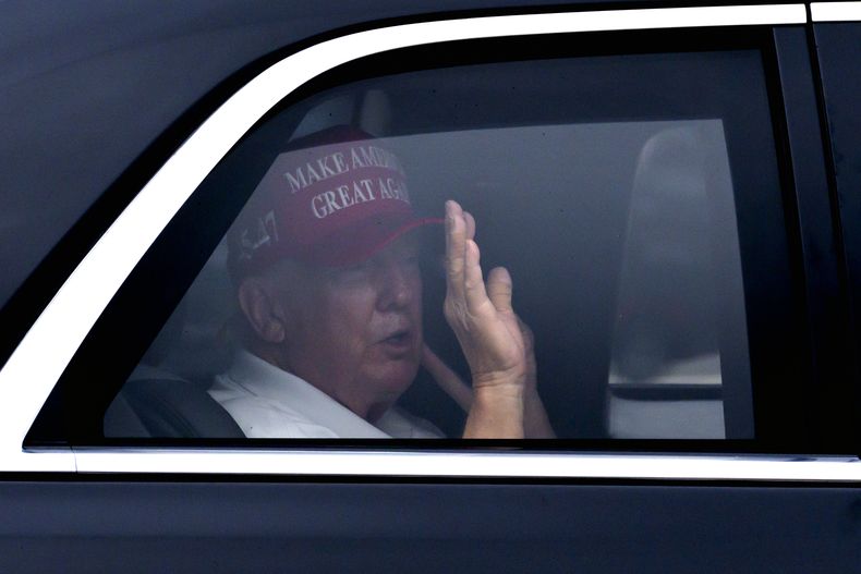 El presidente Donald Trump saluda desde su vehículo a su llegada al Trump International Golf Club, el lunes 17 de febrero de 2025, en West Palm Beach, Florida. (AP foto/Ben Curtis)