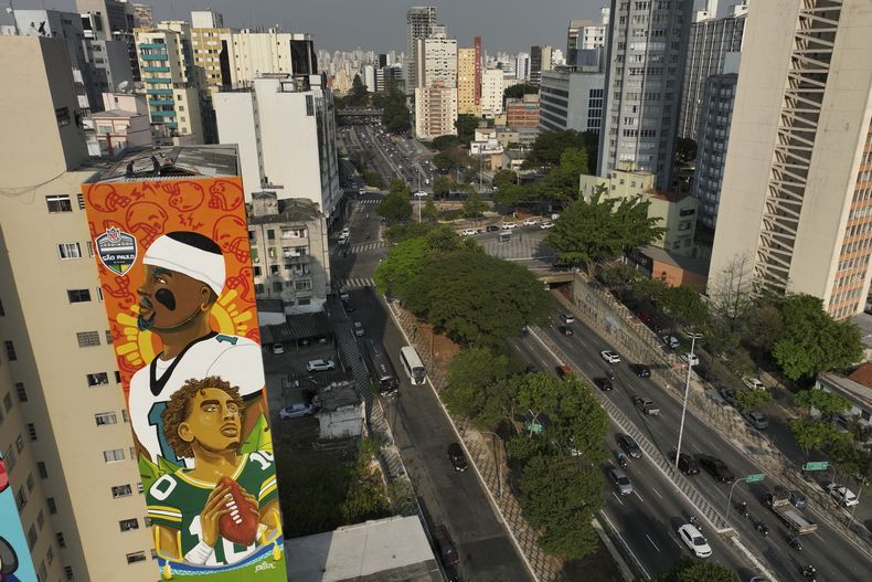 Un mural creado por la artista Crica muestra a los quarterbacks de los Eagles de Filadelfia, Jalen Hurts, y de los Packers de GReen Bay, Jordan Love, en Sao Paulo, el miércoles 4 de septiembre de 2024 (AP Foto/Andre Penner)