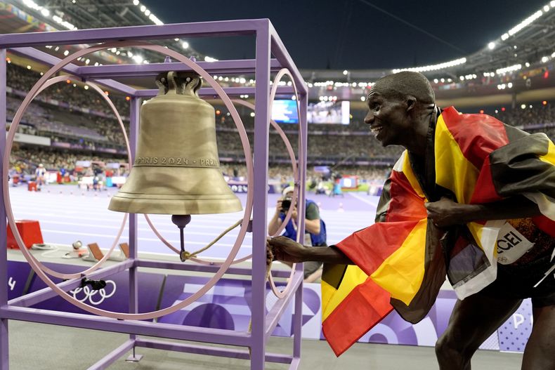 El ugandés Joshua Cheptegei suena la campana tras ganar los 10.000 metros de los Juegos Olímpicos de París, el viernes 2 de agosto de 2024, en Saint-Denis, Francia. (AP Foto/Matthias Schrader)