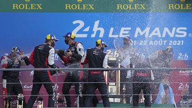 ARCHIVO - Los pilotos ganadores del equipo Toyota Gazoo Racing, el británico Mike Conway, el japones Kamui Kobayashi y el argentino José María López, y los del segundo lugar, el suizo Sebastien Buemi, el japónes Kazuki Nakajima y el neocelandés Brendon Hartley, festejan en el podio al término de la carrera de resistencia de las 24 horas de Le Mans, en Francia, el 22 de agosto de 2021. (AP Foto/Francois Mori, Archivo)