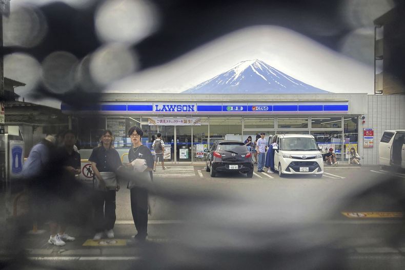 El monte Fuji visto desde un agujero en una pantalla negra colocada frente a una tienda de conveniencia en la localidad de Fujikawaguchiko, en el centro de Japón, el 24 de mayo de 2024. (Kyodo News vía AP)