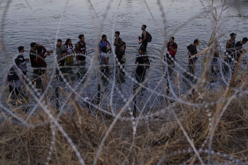 ARCHIVO - Migrantes esperan después de cruzar el río Bravo y entrar en Estados Unidos, el 23 de septiembre de 2023, en Eagle Pass, Texas. (AP Foto/Eric Gay, Archivo)