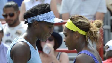 americateve | Venus Williams (izquierda) y su hermana Serena caminan hacia sus respectivas sillas durante una pausa en su partido semifinal en el torneo de Montreal, el s&aacute;bado 9 de agosto de 2014 (AP Foto/The Canadian Press, Paul Chiasson)