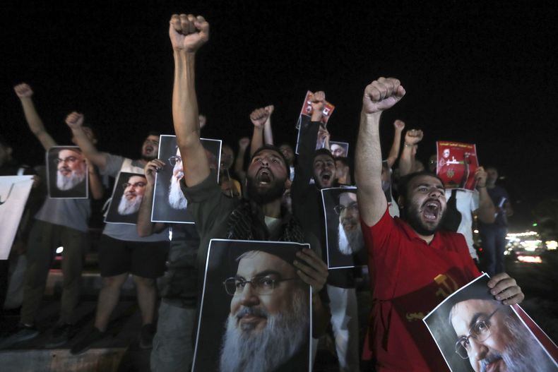 Hombres libaneses y palestinos sostienen retratos del líder de Hezbollah, Sayyed Hassan Nasrallah, mientras gritan consignas durante una protesta en la ciudad portuaria meridional de Sidón, Líbano, el sábado 28 de septiembre de 2024. (Foto AP/Mohammed Zaatari)