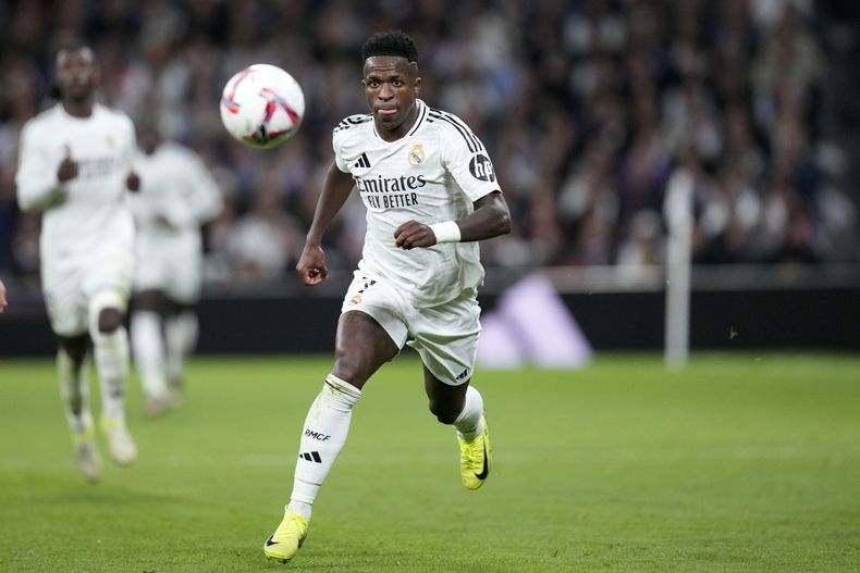 Vinicius Junior, del Real Madrid, corre con el balón durante un partido de La Liga entre el Real Madrid y el Barcelona en el estadio Santiago Bernabéu en Madrid, España, el sábado 26 de octubre de 2024. (AP Foto/Bernat Armangue).