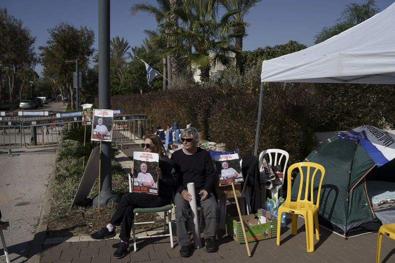 Familiares y amigos de los rehenes retenidos en Gaza, sentados en un campamento en el exterior de la residencia privada del primer ministro israelí, Benjamin Netanyahu, en Caesarea, Israel, el 20 de enero de 2024, en apoyo del padre de un cautivo que inició una huelga de hambre. (AP Foto/Leo Correa)