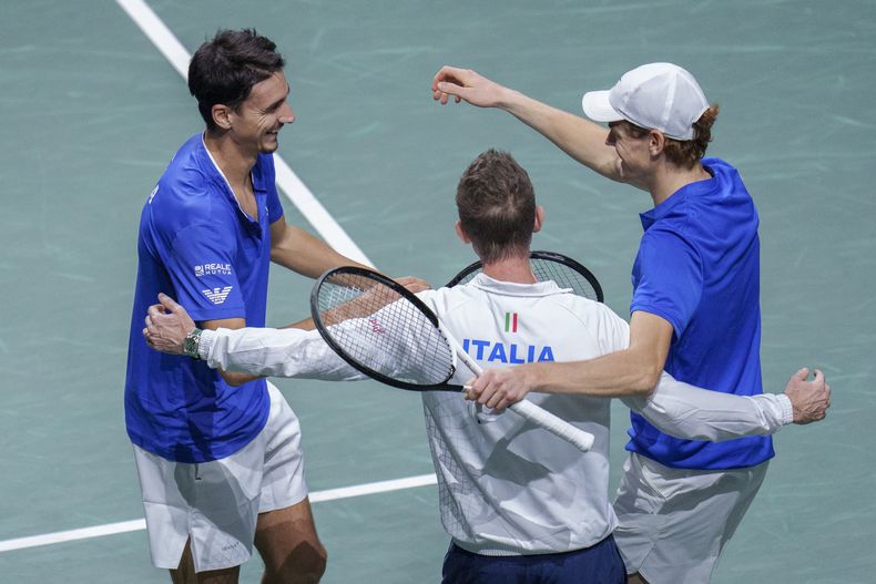 Jannik Sinner celebra con su compañero Lorenzo Sonego y el capitán de Italia Filippo Volandri tras vencer a los serbios Novak Djokovic y Miomir Kecmanovic en la semifinal de la Copa Davis en Málaga, España el sábado 25 de noviembre del 2023. (AP Foto/Manu Fernandez)