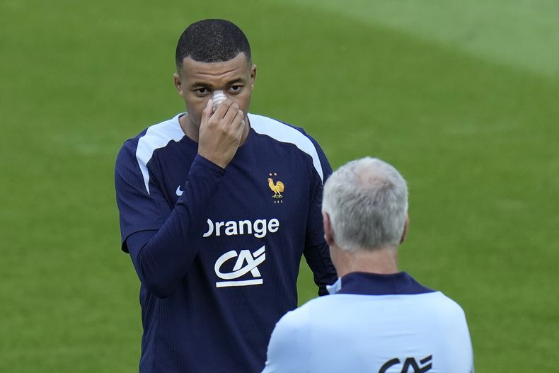 El francés Kylian Mbappe habla con el seleccionador Didier Deschamps durante una sesión de entrenamiento en Paderborn, Alemania el 19 de junio del 2024. (AP Foto/Hassan Ammar)
