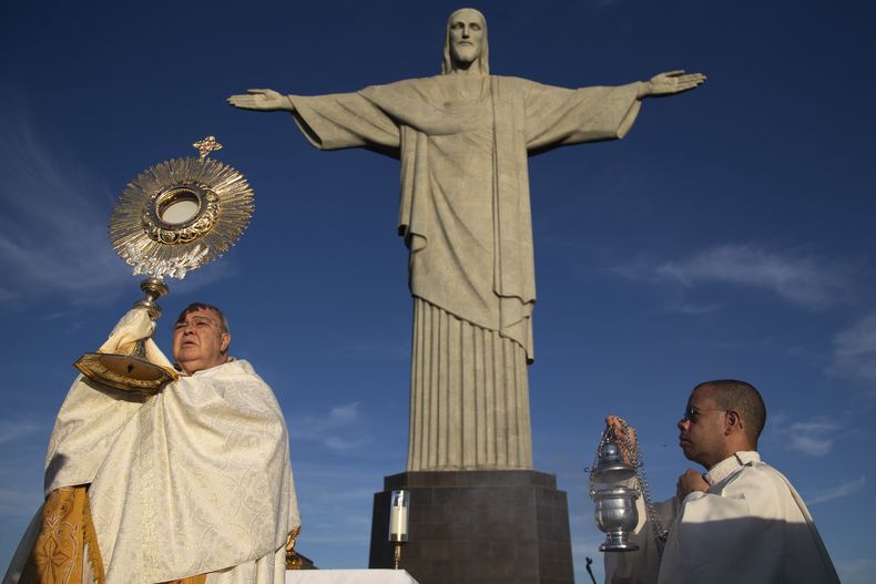 El arzobispo de Río de Janeiro, cardenal Orani Joao Tempesta (izq), celebra una misa con motivo del feriado católico de Corpus Christi en la estatua de Cristo Redentor en Río de Janeiro, el 19 de junio del (AP foto/Bruna Prado)