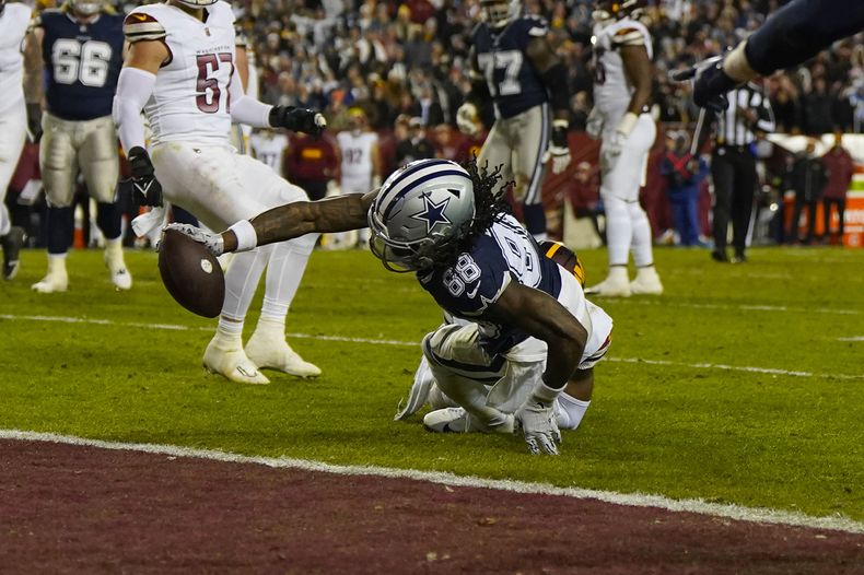 El wide receiver CeeDee Lamb (88), de los Cowboys de Dallas, extiende su brazo para que el balón cruce el plano de la zona de anotación para conseguir un touchdown en contra de los Commanders de Washington durante la primera mitad del juego de la NFL el domingo 7 de enero de 2024, en Landover, Maryland. (AP Foto/Jessica Rapfogel)
